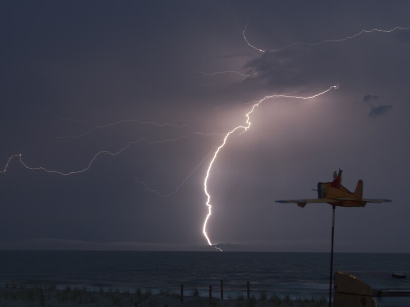 Lightning strike with aircraft silhouette at night