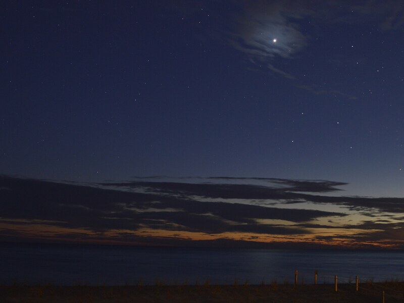 Twilight ocean scene with bright moon