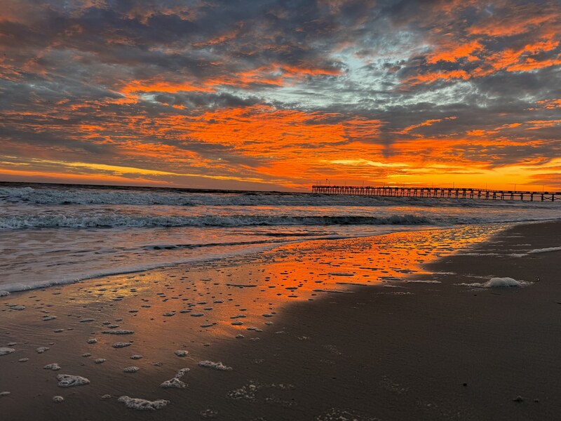 Sunrise reflections on wet sand