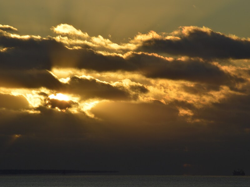 Sunbeams breaking through the coastal sky